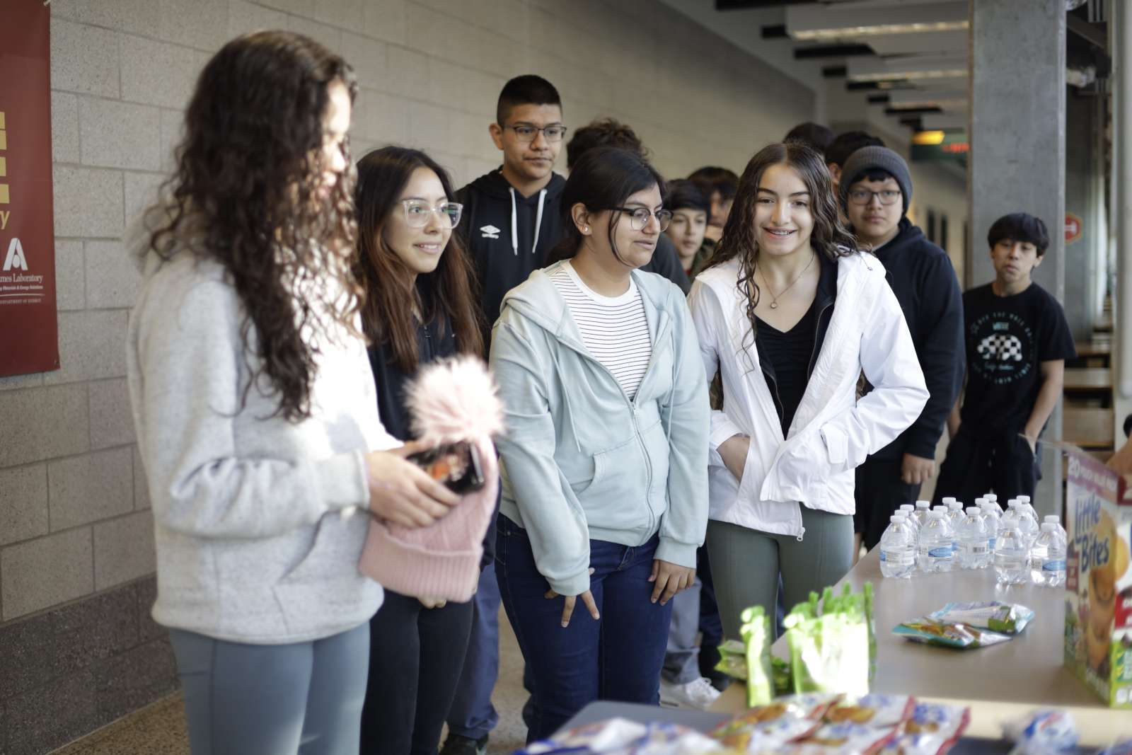 Students in a group getting snacks from a table.